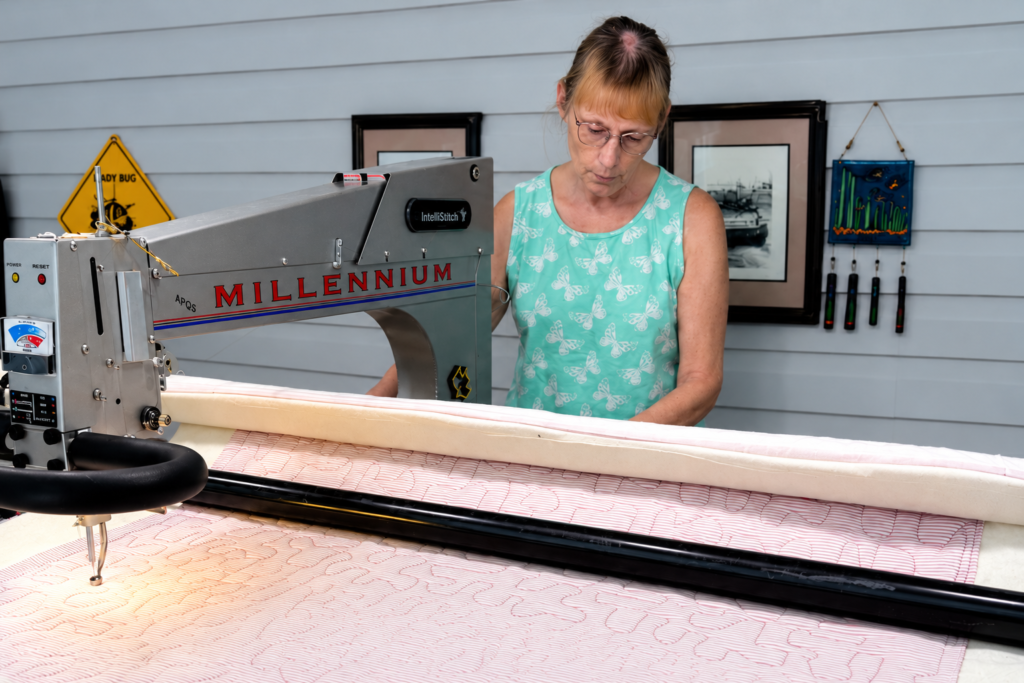 Longarm quilter preparing a quilt on a quilting machine
